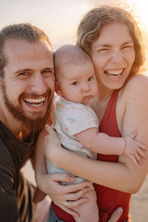 Free Happy family with a baby enjoying quality time and laughter outdoors. Stock Photo