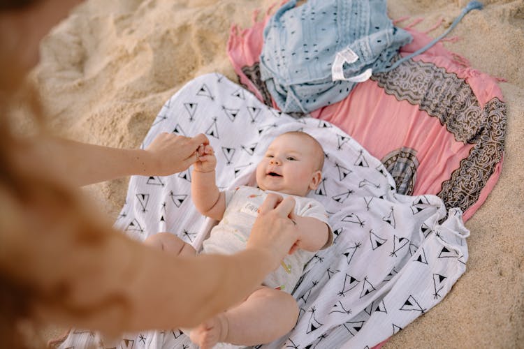 Baby Lying On White And Black Textile