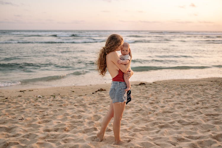 Mother Holding Baby On Beach