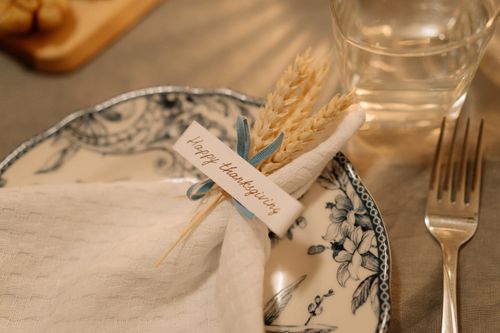 Free Beautiful Thanksgiving table setting with decorated plate and napkin featuring wheat and a festive greeting card. Stock Photo
