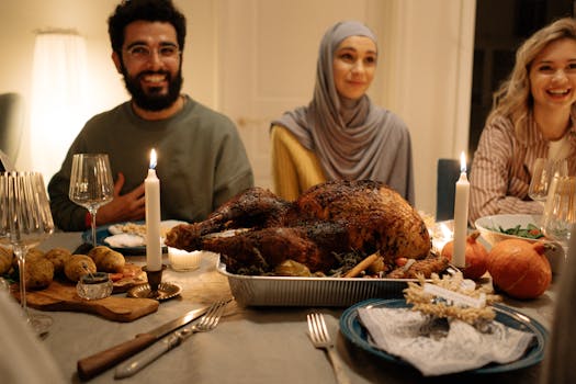 A diverse group of adults enjoying a traditional holiday dinner indoors with a roast turkey centerpiece.