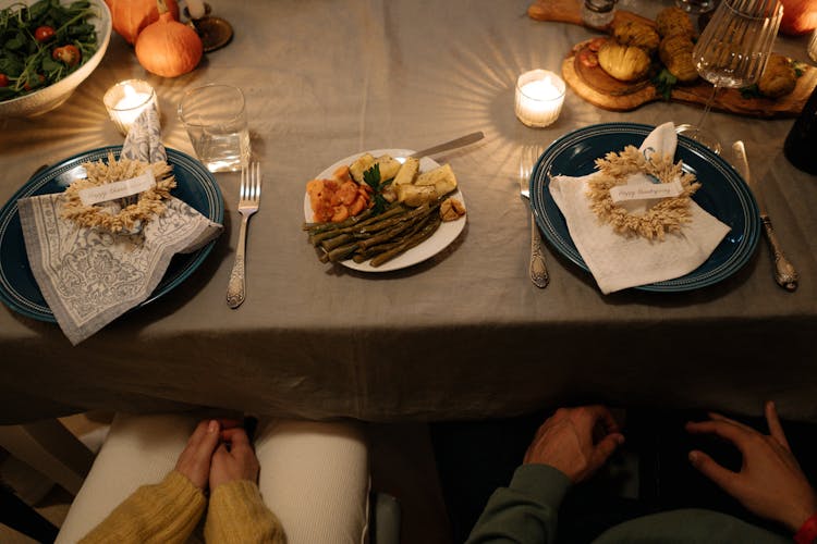 Person In Black Long Sleeve Shirt Sitting Beside Table With Foods