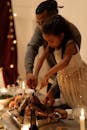 Man in Gray Long Sleeve Shirt Helping his Daughter Slicing the Turkey