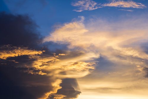 Free A dramatic cloudscape featuring vibrant sunset hues and dynamic cloud formations. Stock Photo