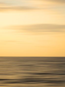 Serene ocean sunset with calm waters and a golden sky in Puerto Vallarta, Mexico.