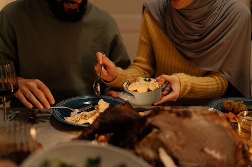 A Person in Yellow Long Sleeve Shirt Holding Blue Bowl with Food