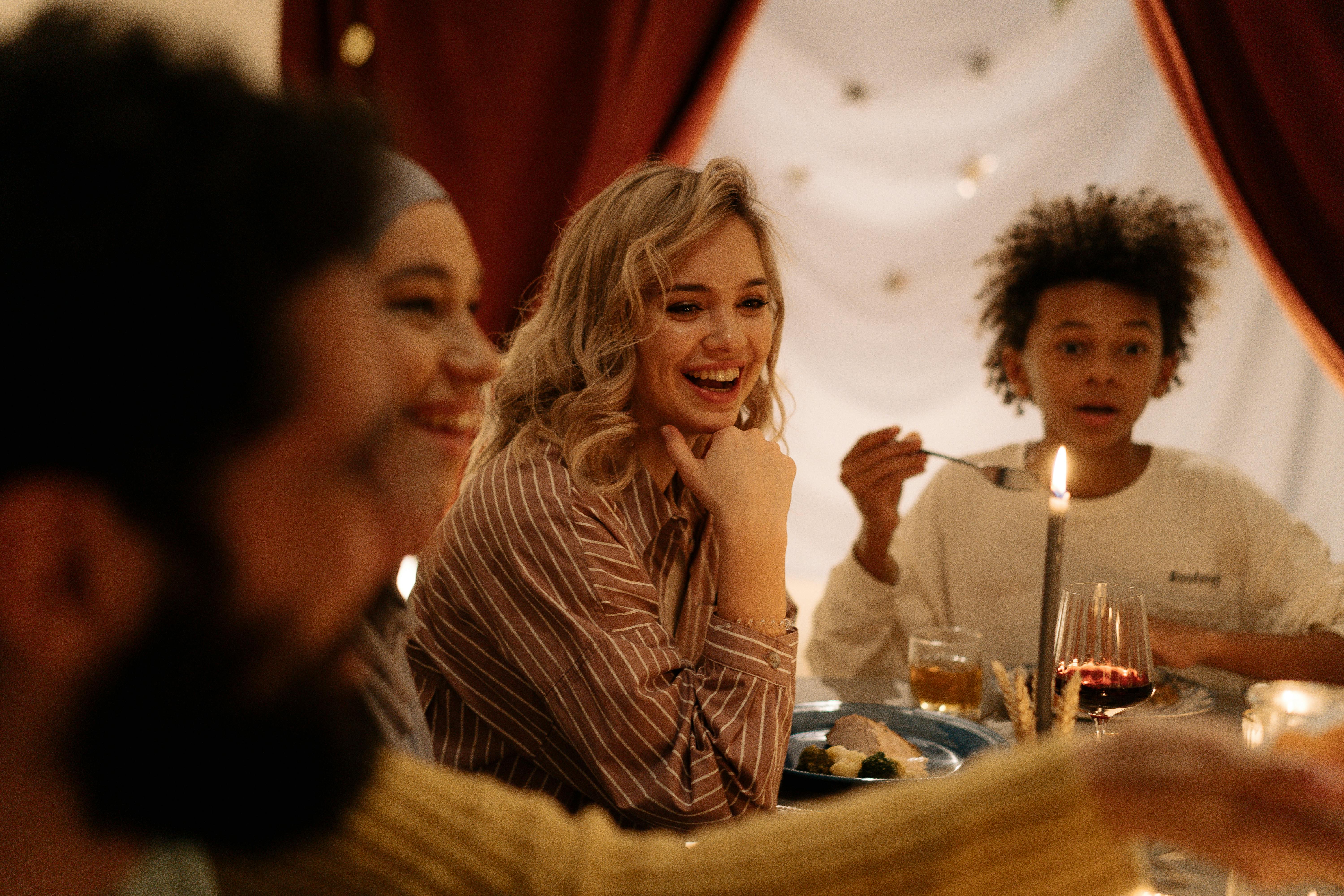 在室内，不同的朋友和家人欢聚一堂，共享一顿温暖快乐的晚餐，分享食物和欢笑