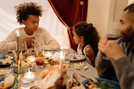 Children talking across a candlelit table — photo by cottonbro studio on Pexels
