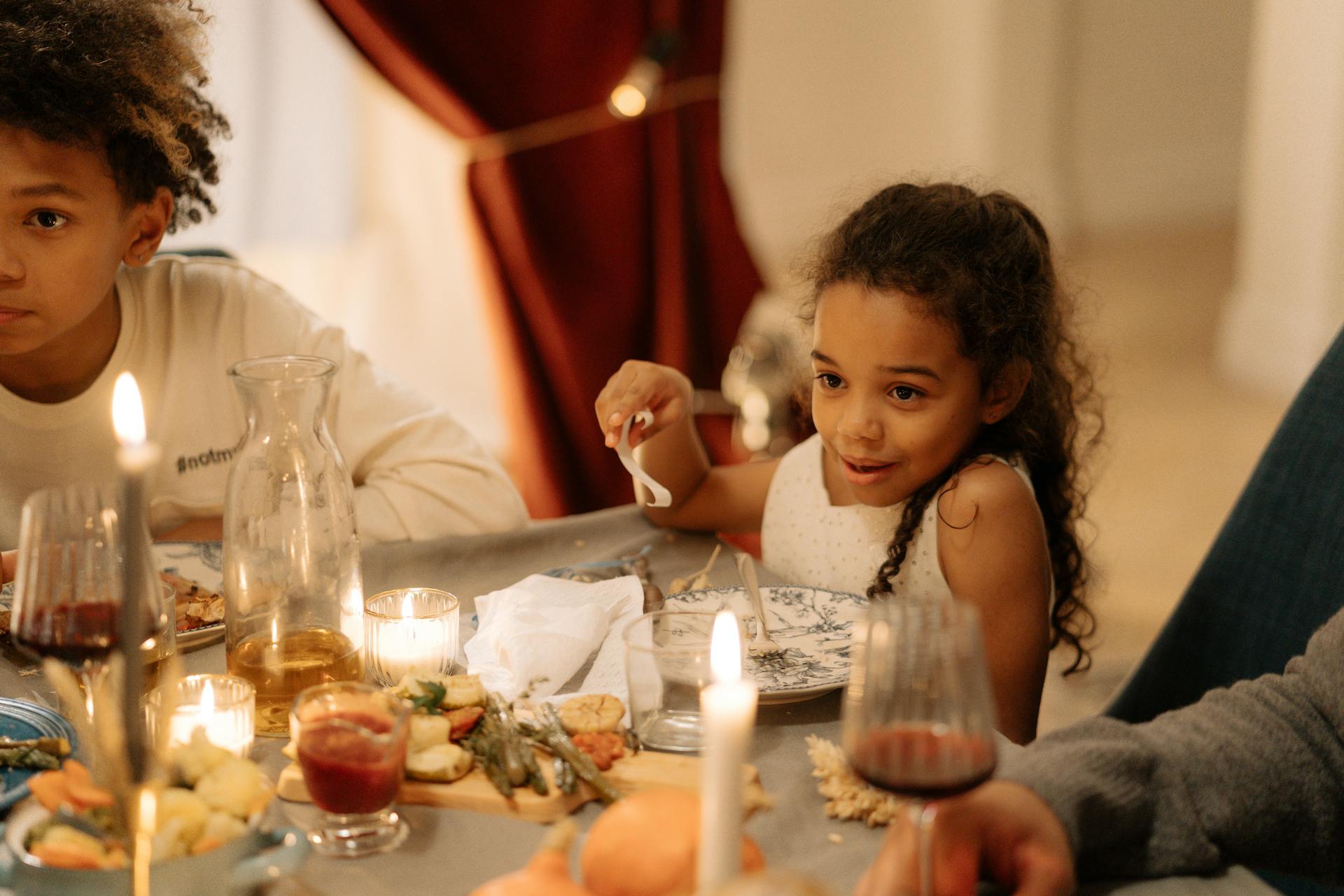 Warm family gathering around a dinner table lit with candles, capturing togetherness and festive spirit.