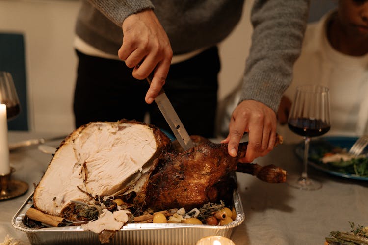 Person Slicing Turkey On A Tray 