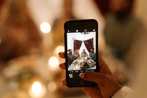 Free A family gathers for a holiday dinner, captured creatively through a smartphone lens. Stock Photo