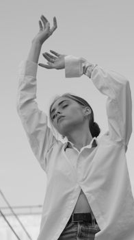 Black and white photo of a woman with raised arms and closed eyes.