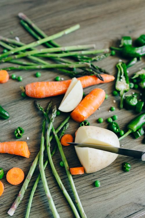 Free A vibrant assortment of vegetables including carrots, peas, and asparagus on a wooden surface. Stock Photo