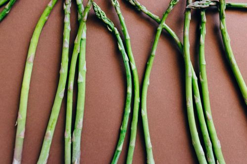 Free Top view of fresh organic asparagus arranged on a brown background. Stock Photo