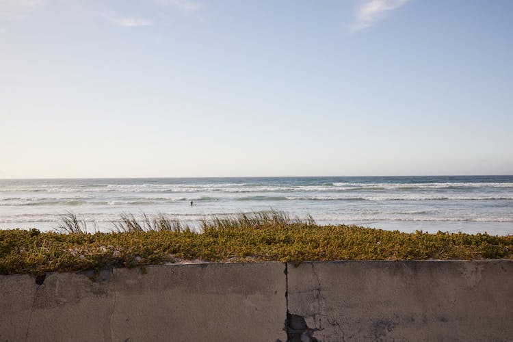 Cement Fence Near Rippling Sea