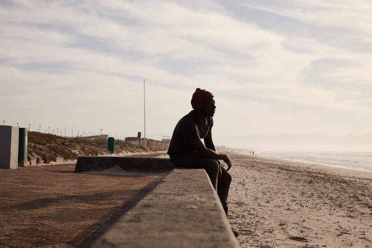 Black Man Sitting On Stone Border