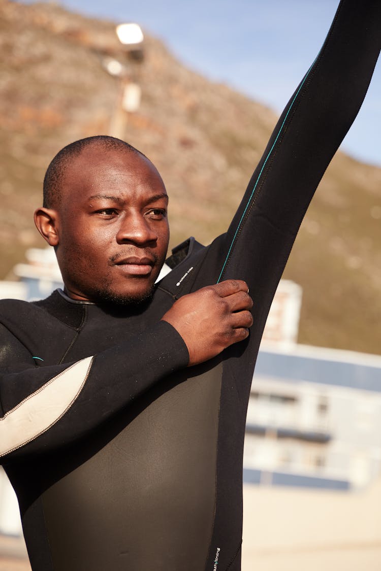 Dreamy Black Athlete Putting On Diving Suit On Beach