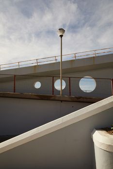 一座现代城市桥梁，在蓝天下展示出其独特的圆形切口与建筑几何形状