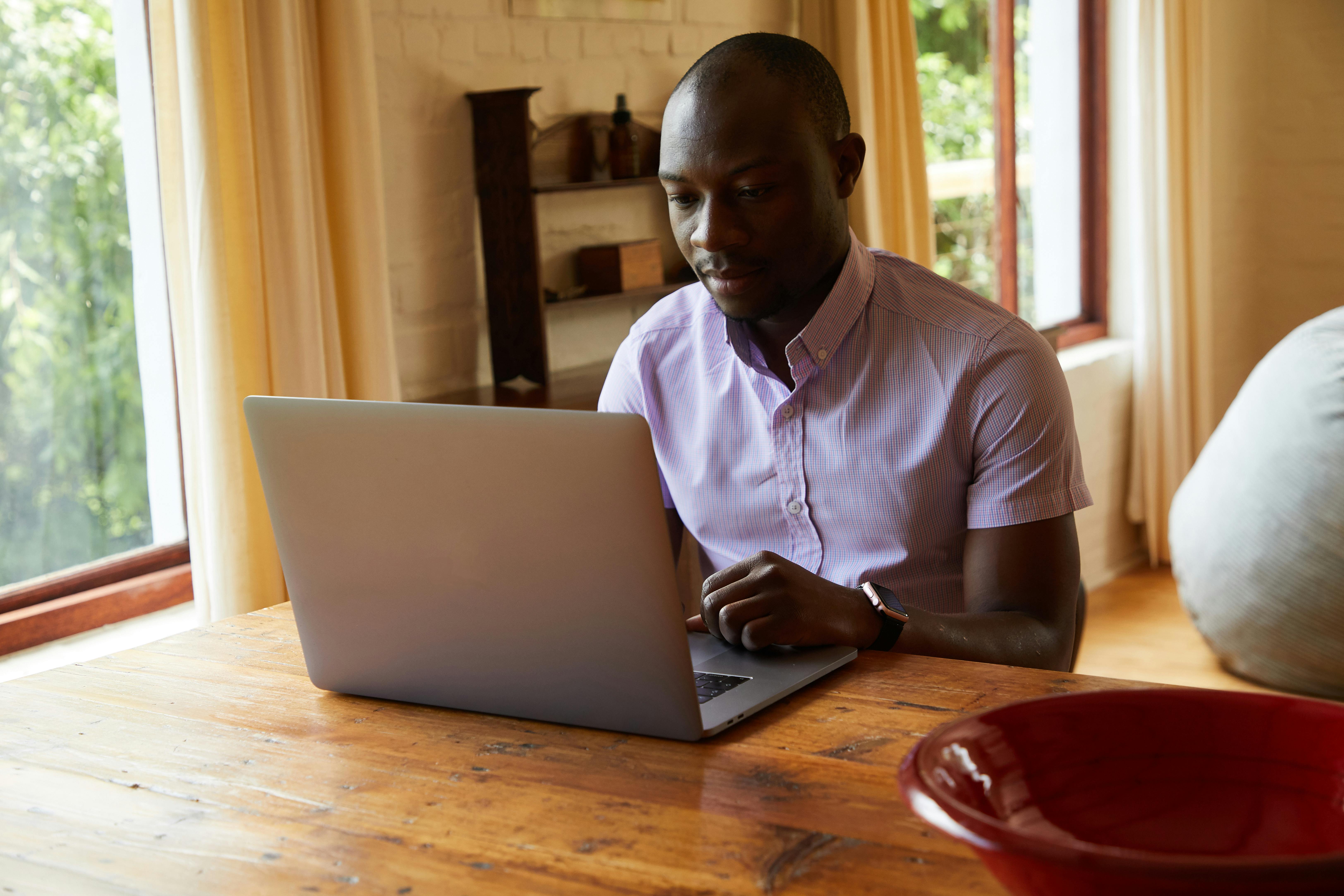 concentrated black man working on laptop