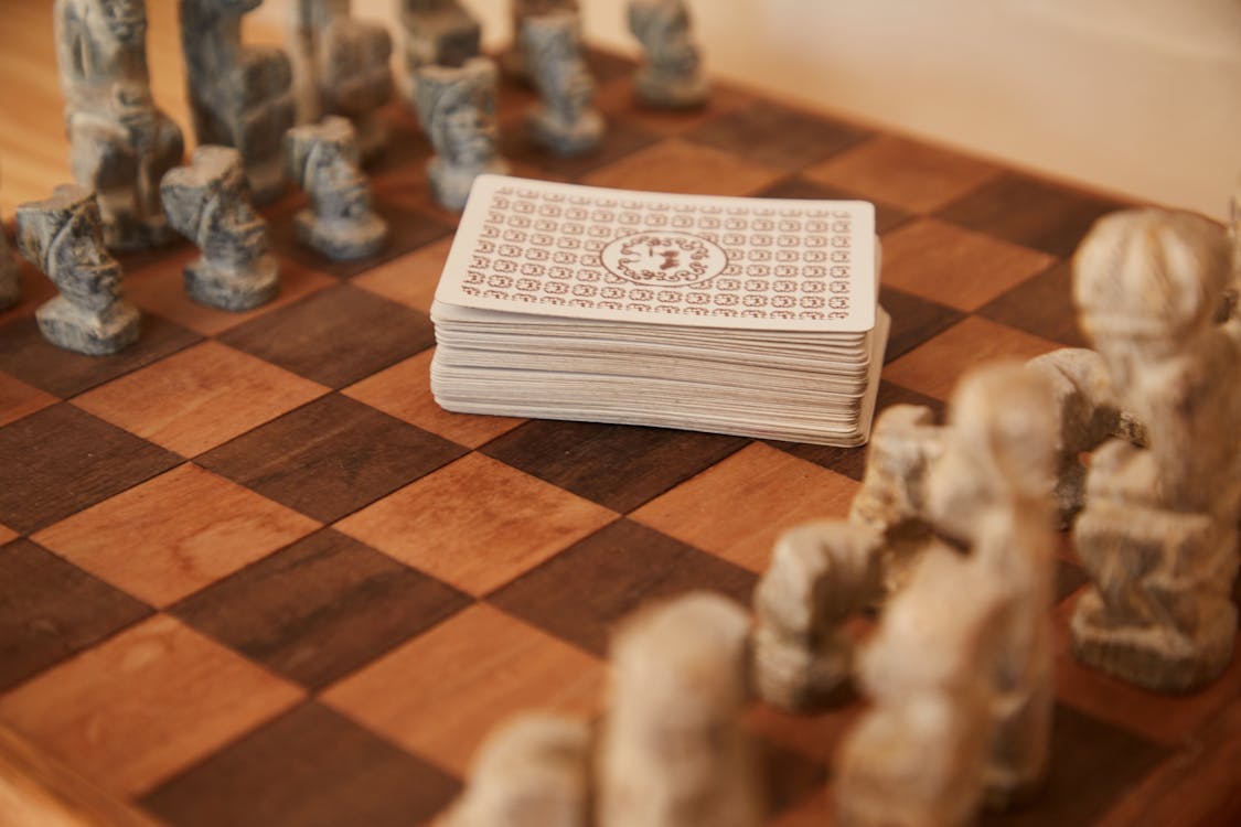 Chessboard with chess pieces and game of cards