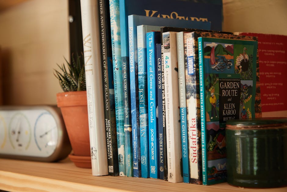 Wooden shelf filled with different interesting books near pots with green plants at home