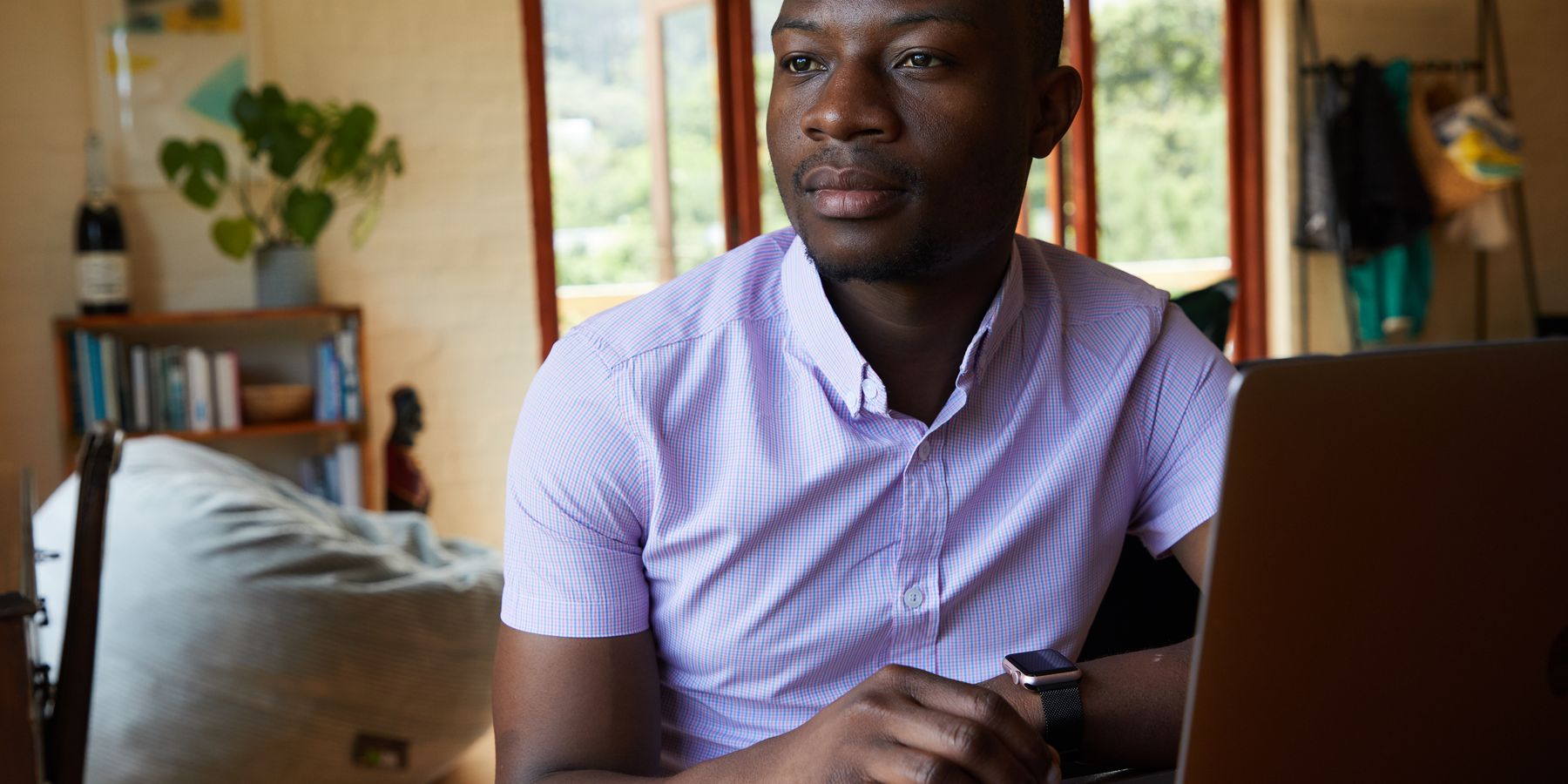 Entrepreneur africain réfléchissant à son orientation professionnelle devant un ordinateur portable