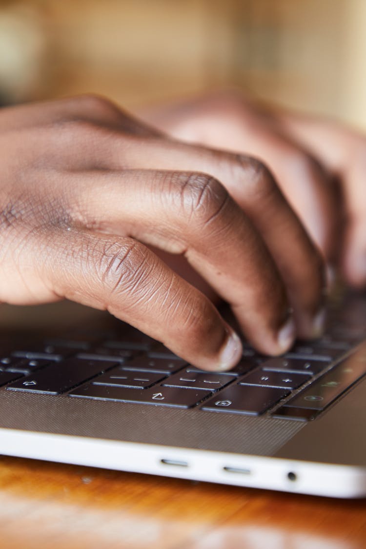 Black Man Using Keyboard Of Laptop