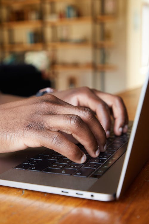 Black man typing on laptop in room