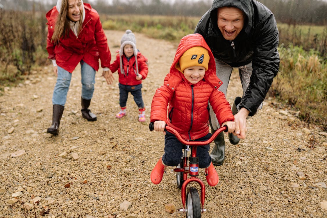 Free Girl in Red Jacket Riding Bicycle Stock Photo