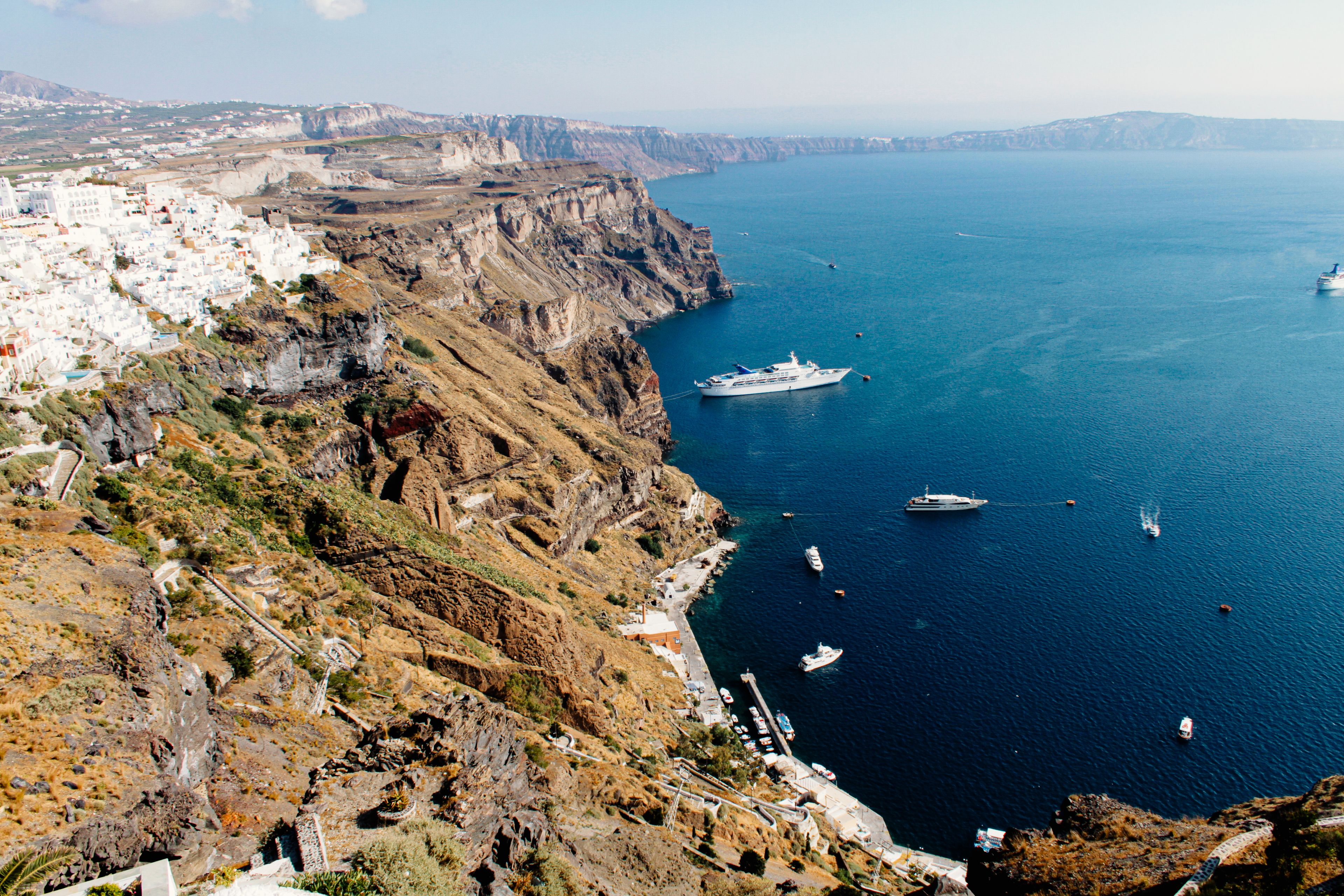 A breathtaking aerial view of Thera, Greece with its iconic cliffs and the serene Aegean Sea.