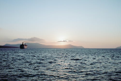 Ship Sailing in Ocean on Sunset