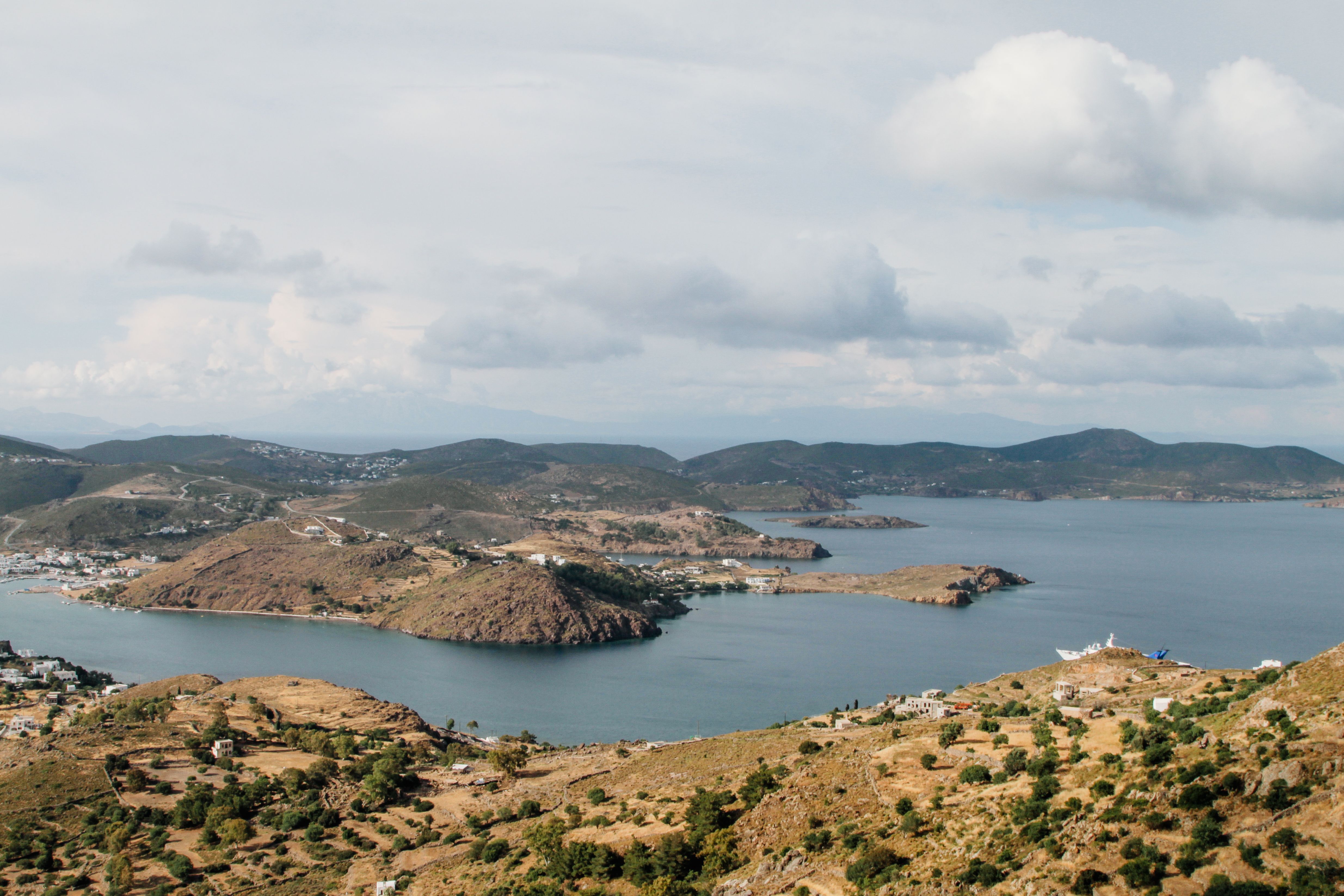 Breathtaking aerial view of Greek islands and coastline under a cloudy sky.