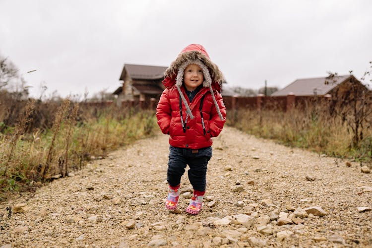 A Child Wearing A Red Puffer Jacket 