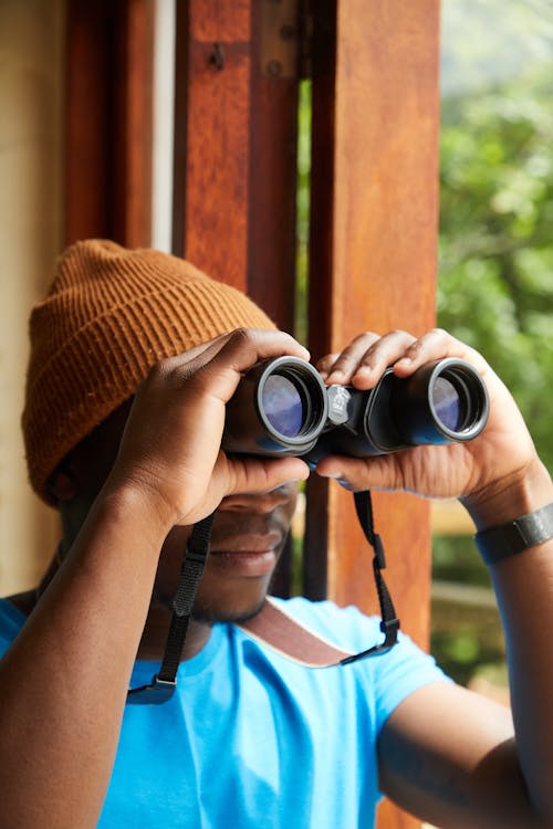 Free Black man with binoculars near balcony Stock Photo