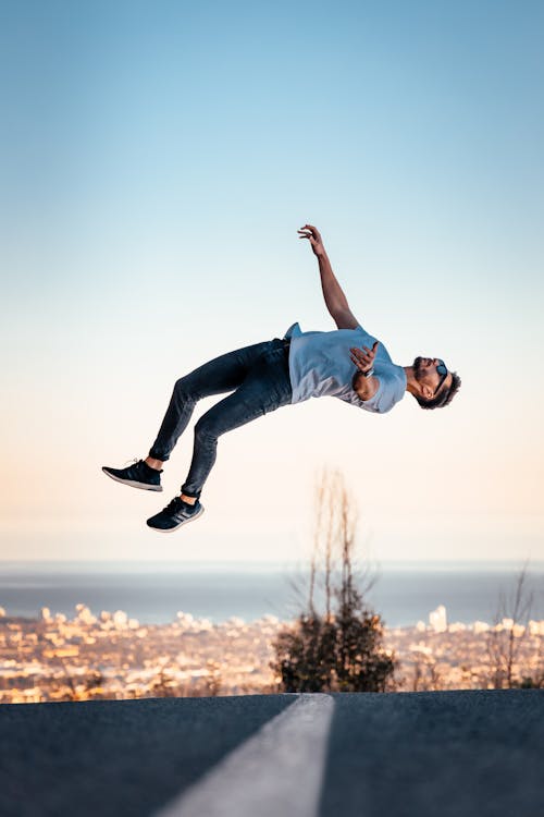 Man in Blue T-shirt and Blue Denim Jeans Jumping on Air