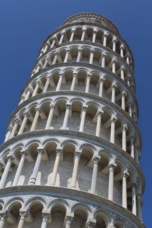 Free Low-angle view of the iconic Leaning Tower of Pisa in Italy against a clear blue sky. Stock Photo