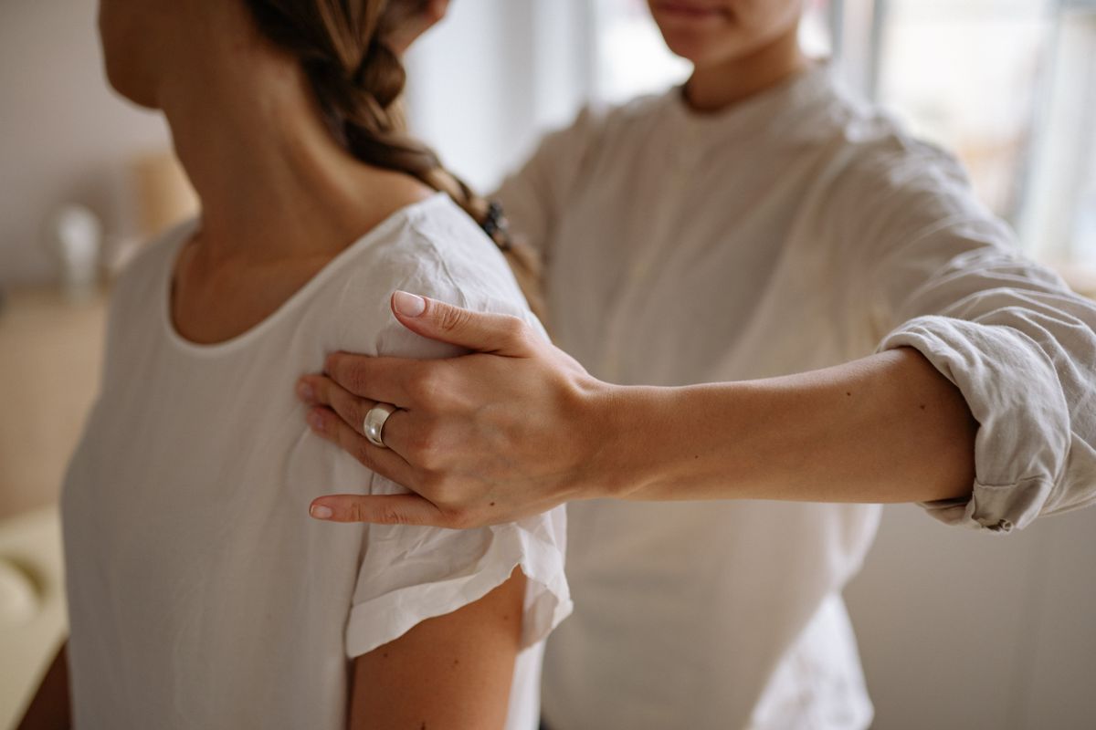 Clinician performing hands-on shoulder assessment in clinic