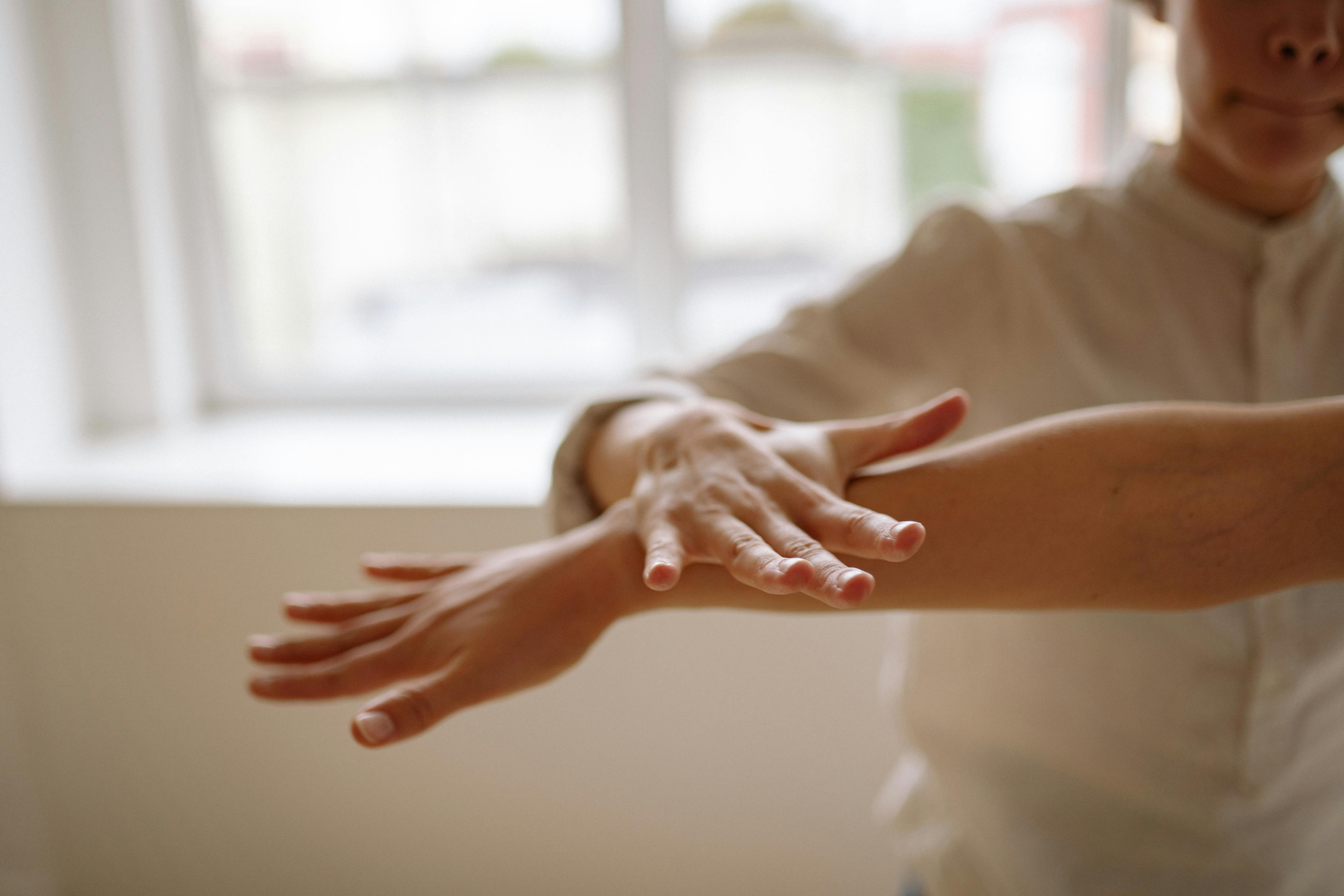 Free A close-up view of a person using a relaxation technique with hands in motion, in a bright, airy space. Stock Photo