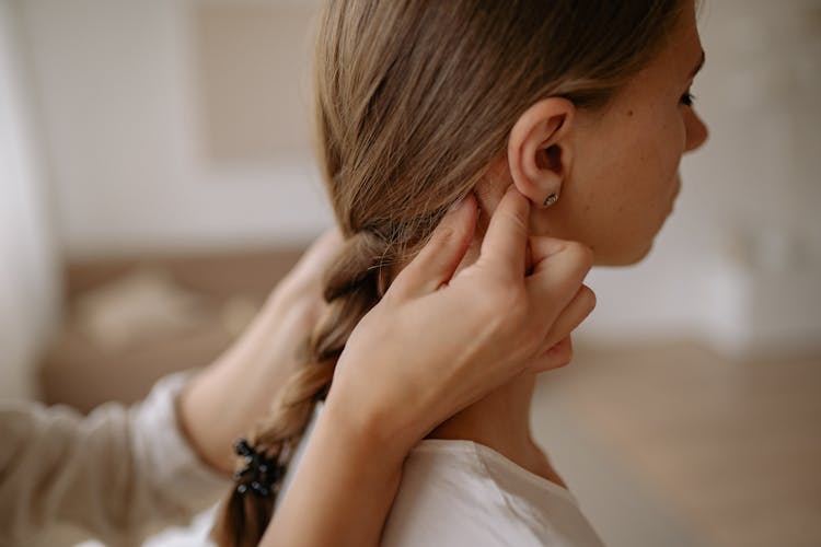 Person Braiding A Young Woman's Hair 