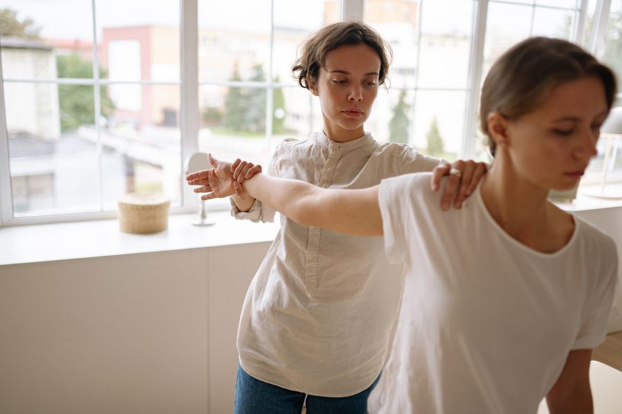 Therapist guiding a patient through a stretching exercise