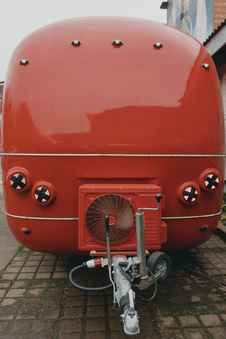 Red And Gray Vehicle Parked On Gray Pavement