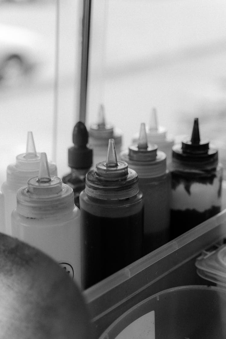 
A Grayscale Of Condiments In Squeeze Bottles