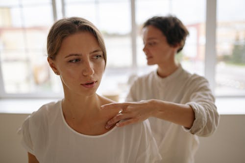 A Therapist Massaging a Client's Shoulder