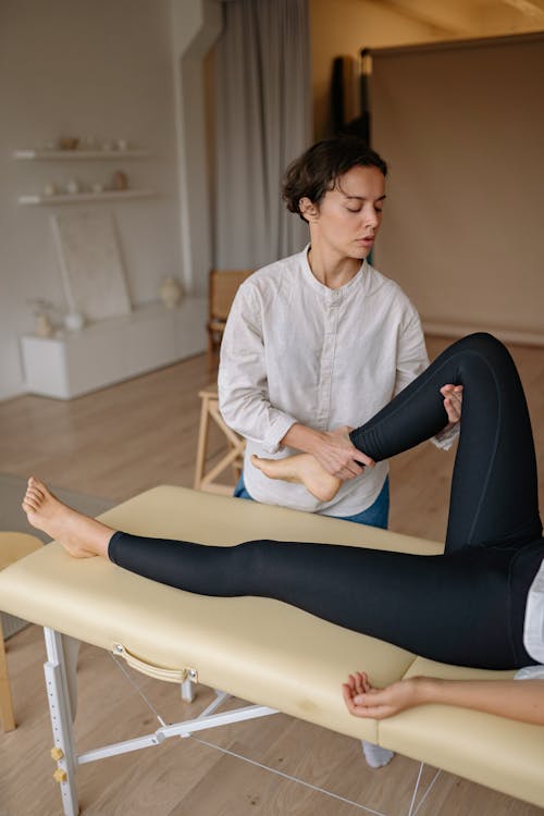 Free A Therapist Massaging the Leg of a Client Stock Photo