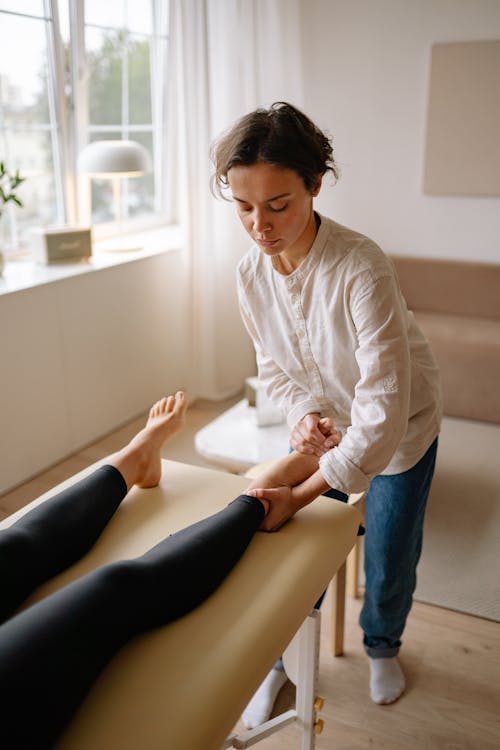 Free A Therapist Holding a Patient Foot Stock Photo
