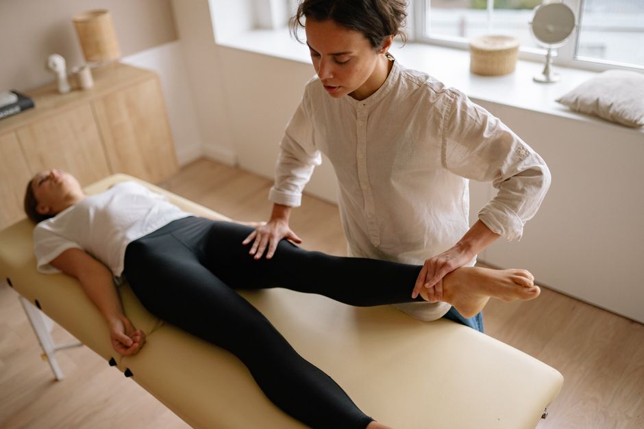 Physiotherapist assists a woman with leg rehabilitation therapy