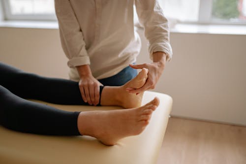 Free A Massage Therapist Massaging a Client's Foot Stock Photo