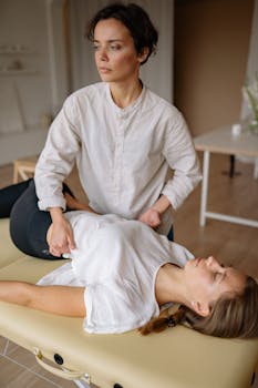 Therapist conducting chiropractic treatment on a patient indoors.