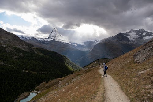 Tourist standing on footpath in mountainous terrain