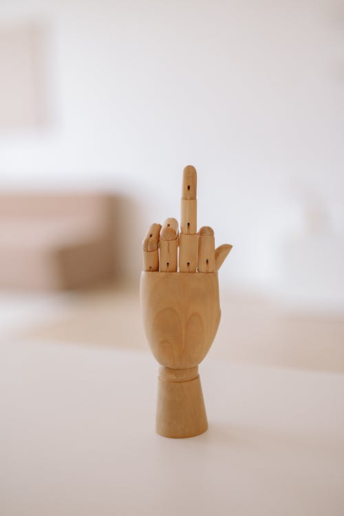 Free Wooden Model Hand with Middle Finger Sticking out Stock Photo